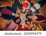 Diverse group of people lying on the floor, surrounded by confetti. Smiling men and women, various ethnicities, enjoying a festive celebration together. Drunk people at New year