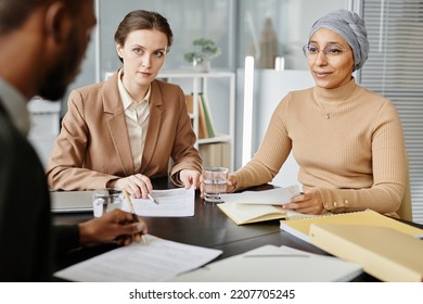 Diverse Group Of People In Meeting Or Job Interview At Office Setting, Focus On Two Young Business Women Listening To Candidate