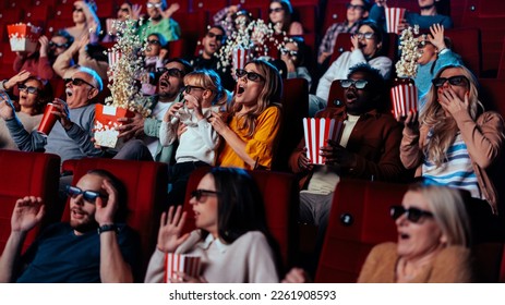 A diverse group of people are in the movie theater watching a 3D movie. They are being frightened by a scary scene and are throwing popcorn into the air out of fear. - Powered by Shutterstock