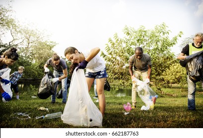 Diverse Group Of People Picking Up Trash In The Park Volunteer Community Service