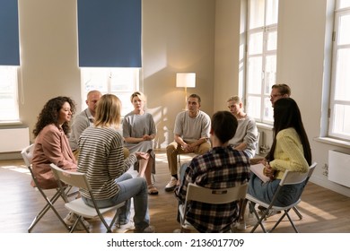 Diverse group of people sat in circle for a Therapy recovery meeting - Shutterstock ID 2136017709