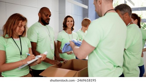 Diverse Group Of People Sorting Clothes Donations - Powered by Shutterstock