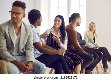 Diverse group of people speaking English at language learning center. Multi ethnic adult students sitting on row of chairs, talking to each other, discussing ideas, and practicing communicative - Shutterstock ID 2192421171