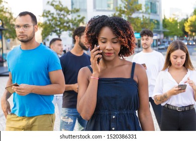 Diverse Group Of People Using Their Smartphones While Walking Down Street. Mix Raced Men And Women Walking Outside, Talking On Cells, Using Mobile Phones. Mobile Connection Concept