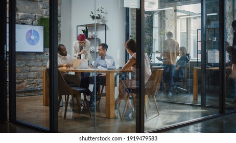 Diverse Group Of Professional Businesspeople Meeting In The Conference Room. Creative Team Discuss App Design, Analyze Data, Plan Marketing Strategy For Social Media. Stylish Busy Business Office