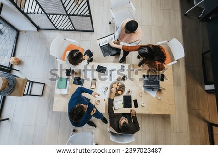 A diverse group of professionals collaborating on a project in a creative office, discussing business solutions and conducting market research for product development.