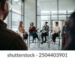 Diverse group of professionals engaging in a lively discussion, sharing expertise during a meeting in a modern office setting.