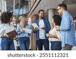 A diverse group of professionals having a collaborative meeting in a modern office space, sharing ideas and discussing projects with laptops and notebooks. They exhibit teamwork and a positive work 