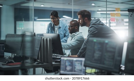 Diverse Group Of Professionals Meeting In Modern Office: Brainstorming IT Programmers Use Computer Together, Talk Strategy, Discuss Planning. Software Engineers Develop Inspirational App Program