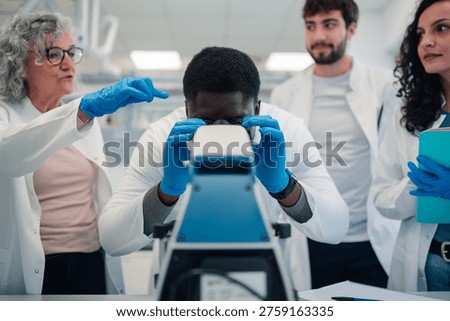 Diverse group of scientists and students working together, conducting research, and analyzing samples with a microscope in a modern lab