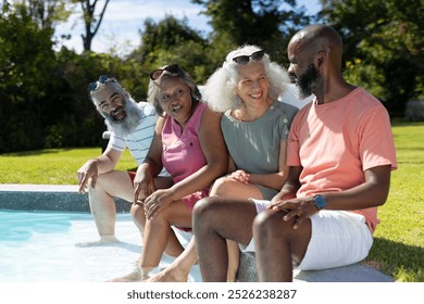 Diverse group of seniors sitting by pool, enjoying sunny day together. friends, outdoor, leisure, summer, elderly, unaltered - Powered by Shutterstock