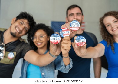 diverse group of smiling friends holding 2024 Vote election I voted buttons or pins at a US election polling station. In the background, american flag at the background, democracy in America USA - Powered by Shutterstock