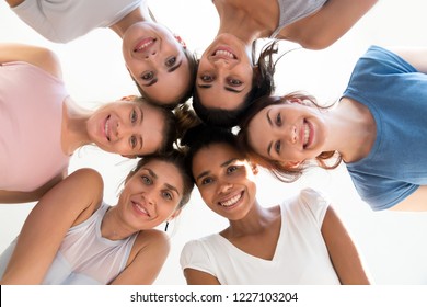 Diverse group of sporty attractive girls enjoy time together, smiling people in sportswear after yoga lesson, mixed race female students, happy friends looking at camera. Well being, wellness concept