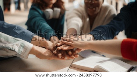 Diverse Group of Students Collaborating in a Library, Hands Joined in Unity. Multiethnic Teamwork Displayed by Young Adults Studying Together, Sharing Ideas and Supporting Each Other Academically