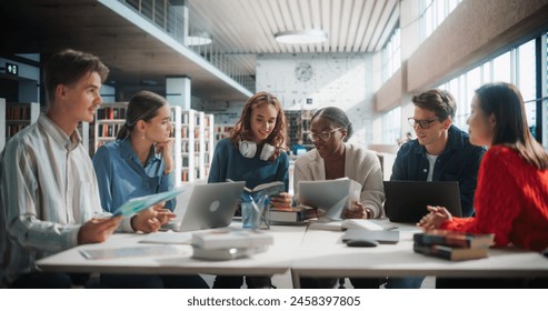 Diverse Group of Students Collaborating on a Project in a Modern Library. Young Adults Using Laptops and Books for Research, Engaged in Academic Discussion with a Focus on Technology and Education. - Powered by Shutterstock