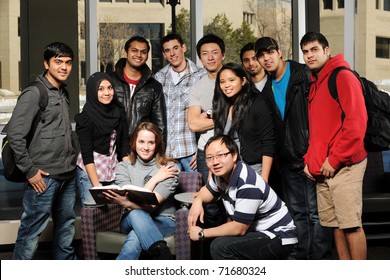 Diverse Group Of Students In College Campus With Buildings On The Background