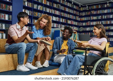 Diverse group of students in college library including young woman in wheelchair enjoying discussion - Powered by Shutterstock