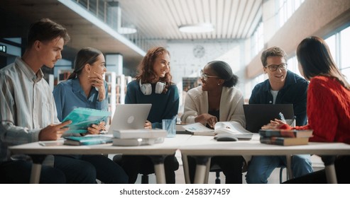 Diverse Group of Students Engaged in a Study Session at a Modern Library. Young Adults Collaborating Over Books and Laptops, Sharing Ideas and Learning Together in a Collegiate Environment. - Powered by Shutterstock