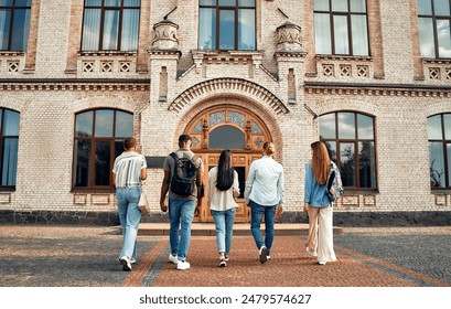 A diverse group of students heading into a historic university building, embodying the values of education and community, on a campus where cultural diversity and academic ambition thrive - Powered by Shutterstock