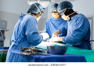 Diverse group of surgeons operating on patient in operating theatre. Surgery, teamwork, hospital, medical and healthcare services. - Powered by Shutterstock