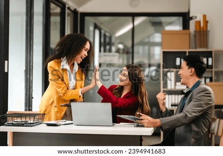 Diverse group of three professionals, two women and man, working together on design project around laptop. Product design team for industrial, working together, Asian man, African american people