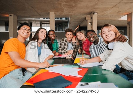 Diverse Group of University Students Share Joyful Moment During Collaborative Study Session, Their Genuine Smiles and Academic Camaraderie Captured While Working on Assignments Together on Campus