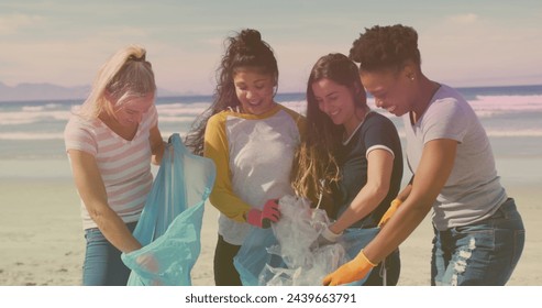 Diverse group of women participate in a beach cleanup. They demonstrate environmental responsibility and teamwork in an outdoor setting. - Powered by Shutterstock