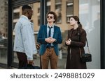 A diverse group of young adults, dressed in smart casual attire, discussing business outdoors near a modern office building.