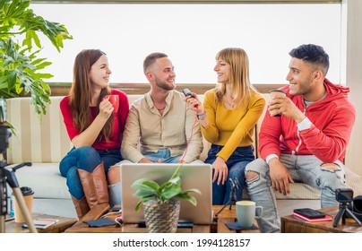 diverse group of young friends sitting on couch broadcasting live streaming online on social media. happy people interacting together with modern technology in a vlog. tech, fun and lifestyle concept