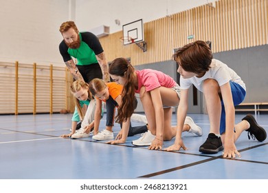 A diverse group of young people stand together on a blue floor as a male teacher instructs them in a bright classroom setting. - Powered by Shutterstock