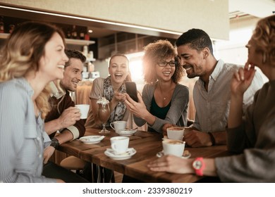 Diverse group of young people talking and having a coffee at a cafe - Powered by Shutterstock