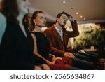 A diverse group of young professionals attentively participating in a formal meeting. The setting suggests a conference or business networking event, highlighting teamwork and collaboration.