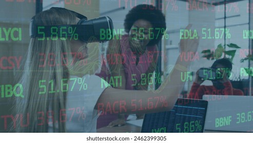 A diverse group of young professionals is working with virtual reality. African American intern wearing VR headset, colleague guiding her, another working on laptop - Powered by Shutterstock