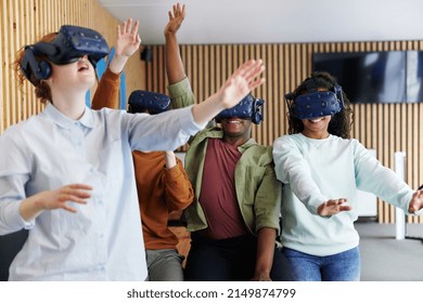 Diverse group of young teenage friends wearing vr headsets to explore an interactive world at a vr club - Powered by Shutterstock