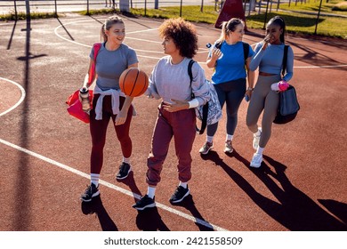 Diverse group of young woman walking on basketball court preparing to play. - Powered by Shutterstock