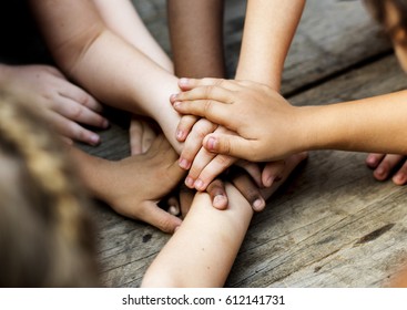 Diverse hands are join together on the wooden table