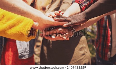 Diverse hands join in unity and cooperation, symbolizing diversity and inclusion.
