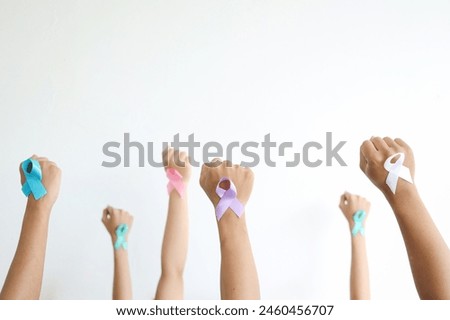 Diverse Hands Raising and Clenching Fist with Colorful Cancer Ribbon to Support and Unite for People with Cancer Illness. 