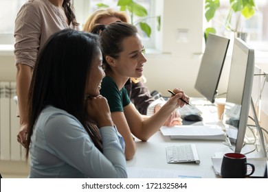 Diverse happy businesswomen thinking in negotiations looking at computer screen. Smiling african american woman and mixed race colleague discuss joint project development.