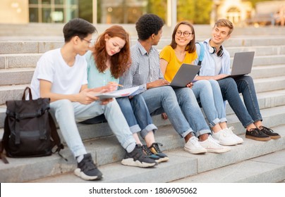 Diverse High-School Students Doing Homework Learning Together Sitting On Steps Outside. School Life Concept