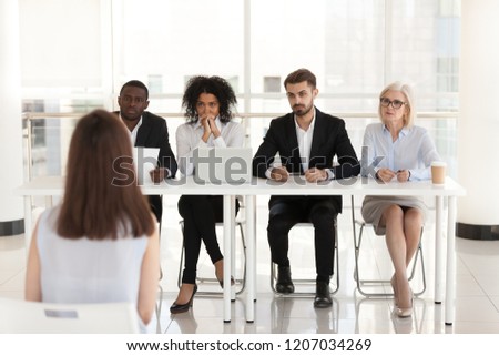 Diverse HR managers listen to female job candidate speaking during work interview in office, multiethnic recruiters consider woman candidature at hiring. Recruitment, employment concept