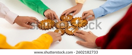 Diverse individuals collaborate hands-on using gears to symbolize teamwork in business. This image represents creativity, communication, and effective problem-solving in a cohesive environment. Amity