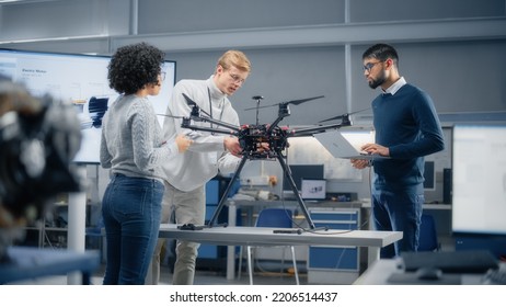 Diverse And Intelligent Science Specialists Looking At Prototype Of The Drone And Talking About It In Scientific Laboratory. Aviation Engineering And Breakthrough In Aviation Technologies Concept.