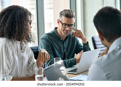 Diverse international executive business people working on project at boardroom meeting table using laptop computers. Multiracial team discussing project strategy working together in modern office. - Shutterstock ID 2024994203