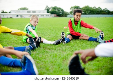 Diverse kids stretching on the field - Powered by Shutterstock