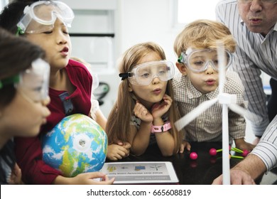 Diverse kindergarten students learning energy producer from solar windmill in science class - Shutterstock ID 665608819