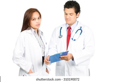 A Diverse Latino Male, Asian Female Team Of Doctors, One Looking At Camera While Other Is Listening, Reviewing, Discussing Medical Charts Diagnosis With Serious, Studious Expressions. Horizontal