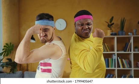 Diverse male couple of unfit weak weird men wearing sportswear, posing back to back looking very self-confident at camera. Sport humor and fun concept.