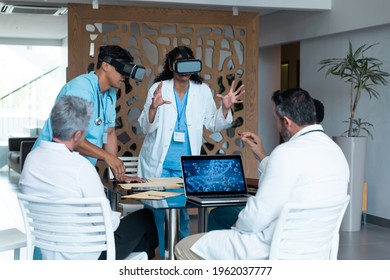 Diverse Male And Female Doctors Wearing Face Masks Sitting At Table And Using Vr Glasses. Medicine, Health And Healthcare Services.