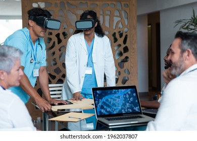 Diverse Male And Female Doctors Wearing Face Masks Sitting At Table And Using Vr Glasses. Medicine, Health And Healthcare Services.